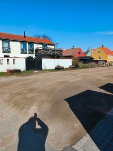 a shadow of a person standing in a parking lot at Gruse 9 Svaneke in Svaneke