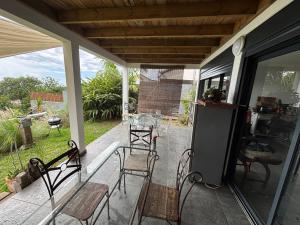 a screened in porch with chairs and a table at Villa Papang in Saint-Paul