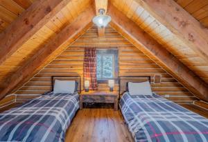 two beds in a room in a log cabin at 20 mins to YNP-Cabin-Pet friendly in Island Park