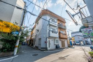 a building on the side of a street at 3 Free Rental Bicycles - Free Parking - 85sqm - Up to 9 Guests - 7min to Koreatown - Japanese Lessons by Professional teacher - 自転車3台無料貸出 - 無料駐車場 - 85平米 - 定員9名 - コリアタウン徒歩7分 - Mintak Katsuyama V Residence in Osaka