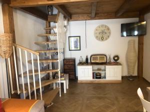a room with a staircase and a clock on the wall at La casetta di Vany in Nova Siri
