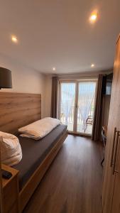 a bedroom with a bed and a large window at Gasthof Söll in Niedertaufkirchen