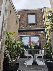 a patio with a table and chairs in front of a brick building at Tip &Top Deluxe Appartement in Vlissingen