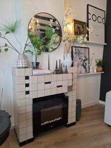 a living room with a fireplace and a mirror at Tip &Top Deluxe Appartement in Vlissingen