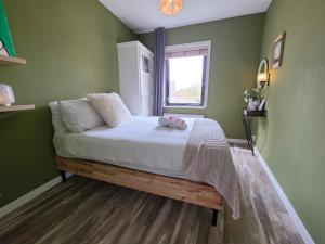 a green bedroom with a bed with a teddy bear on it at Tip &Top Deluxe Appartement in Vlissingen
