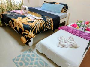 a room with two beds and a rug at Camigs Vacation House in Mambajao