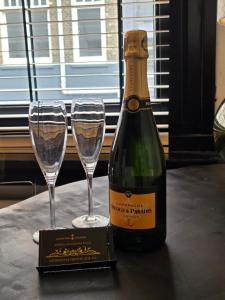 a bottle of champagne and two glasses on a table at Tip &Top Deluxe Appartement in Vlissingen +26 photos
