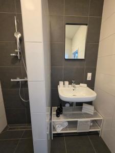 a bathroom with a sink and a mirror at Tip &Top Deluxe Appartement in Vlissingen