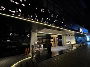 a building with a bar with chairs and lights at Likto Hotel in Guangzhou