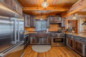 a kitchen with wooden cabinets and a stove top oven at 20 mins to YNP-Cabin-Pet friendly in Island Park