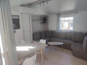a living room with a couch and a table at la bulle d'oxygène in Sérignan