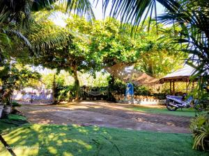 a house with a motorcycle parked under a tree at Camigs Vacation House in Mambajao