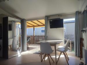 a room with a table and chairs and a tv at la bulle d'oxygène in Sérignan
