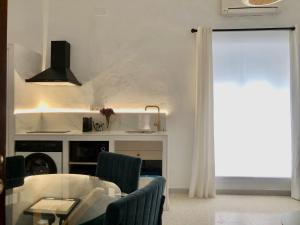 a living room with a table and a kitchen at La casa grande 2 in Carmona