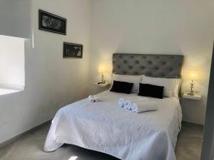 a bedroom with a large white bed with towels on it at La casa grande 2 in Carmona