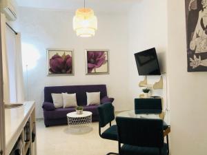 a living room with a purple couch and a table at La casa grande 2 in Carmona +7 photos