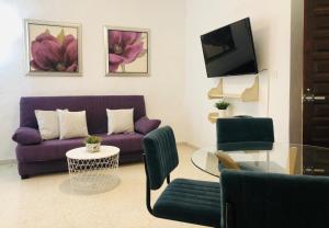 a living room with a purple couch and a glass table at La casa grande 2 in Carmona
