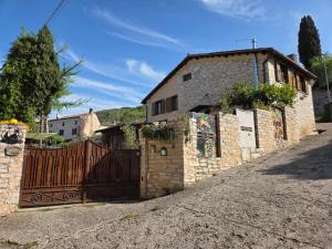 a house with a wooden gate in front of a house at La Volpe e L'Iris in Campiano, Province of Verona