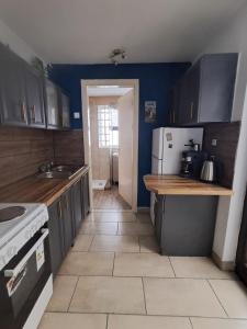 a kitchen with black cabinets and a white refrigerator at The Village Retreat in Malona Village +37 photos