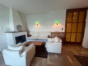 a living room with two white couches and a fireplace at La dolce vela in Muggia