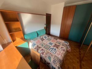 a small bedroom with a bed and a table at La dolce vela in Muggia