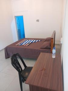 a bedroom with a table and a bed and a bottle of water at Amaya Hotel and Restaurant in Batigama