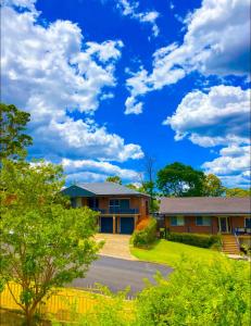 a house with a blue sky and clouds at Family Haven Bradburry in Campbelltown South