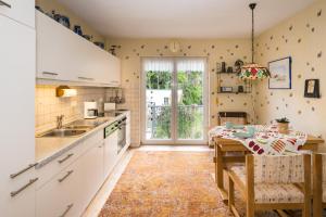 a kitchen with white cabinets and a table at Villa Robert Heuser in Traben-Trarbach
