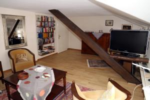 a living room with a television and a table and chairs at Villa Robert Heuser in Traben-Trarbach