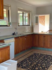 a kitchen with wooden cabinets and a sink at Family Haven Bradburry in Campbelltown South +52 photos