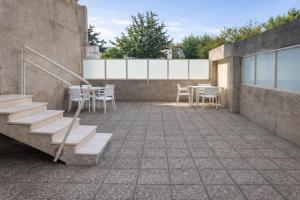 a patio with stairs and tables and chairs on a building at City World Apartment in Maia