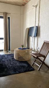 a room with a chair and a table and a television at 201 On Main in Johannesburg
