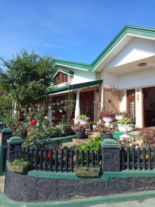 a house with potted plants and a fence at Little England Grand Hotel in Nuwara Eliya