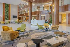 a lobby with chairs and tables in a building at Element by Marriott Al Qassim in Buraydah