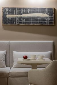 a table with two cups and an apple on a couch at Rooms Buonanotte Barbarossa in Prato