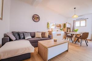 a living room with a couch and a table at TEMPLE JACQUESSON - Gare - Centre ville - WIFI RAPIDE et STREAMING - PARKING GRATUIT - CHECK IN 24H - CLIMATISATION - IDEAL PROS - cour privée - barbecue in Chalons en Champagne