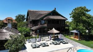 a house with lounge chairs and a swimming pool at Morena Mansion in Murighiol