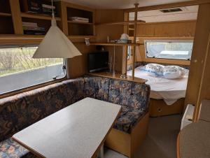 a small room with a couch and a bed at Wohnwagen mit feststehendem Vorzelt in Fehmarn