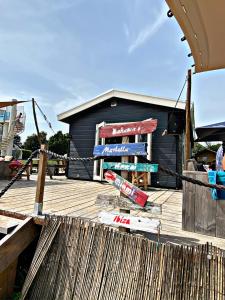 a black building with a sign on a wooden deck at FerienChalet-Icra in Lathum +7 photos
