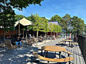 a patio with tables and chairs and people sitting in chairs at FerienChalet-Icra in Lathum