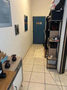 a kitchen with a blue door and a tiled floor at LE MERYCE appt in Saint-Denis