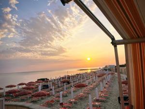a beach with chairs and umbrellas at sunset at Domus Alberta in Lecce