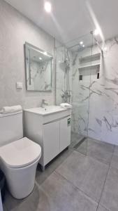 a bathroom with a toilet and a sink and a shower at Ocean Breeze in Porto Moniz +22 photos