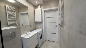 a bathroom with a sink and a washing machine at Aqua Villa 4 in Jurata