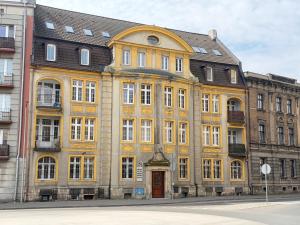 a large yellow building with a brown roof at UNESCO Loft House 24h Tarnowskie Góry Rynek 5 min in Tarnowskie Góry