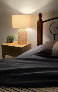 a bedroom with a bed and a table with a lamp at Seascape Cottage on Kangaroo Island in Baudin Beach