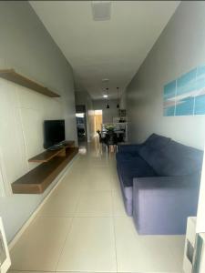 a bedroom with a blue bed and a living room at Dunas residence casa 15- Lençois Maranhense in Santo Amaro