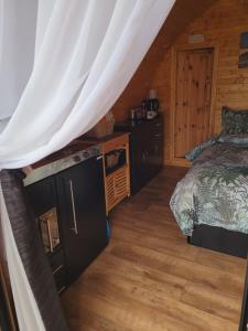 a bedroom with a bed and a wooden floor at Ocean View Glamping Pod in Borve