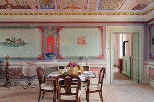 a dining room with a table and paintings on the wall at Hotel Palazzo Vittoria Heritage Collection in Cerveteri