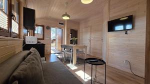 a living room with a couch and a table at LAZY DAYS domek nr 26 w Borsku in Borsk